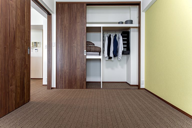 リビング隣の洋室は、建具にウォールナット、アクセントクロスに薄い黄色を使用し落ち着きのある雰囲気に。