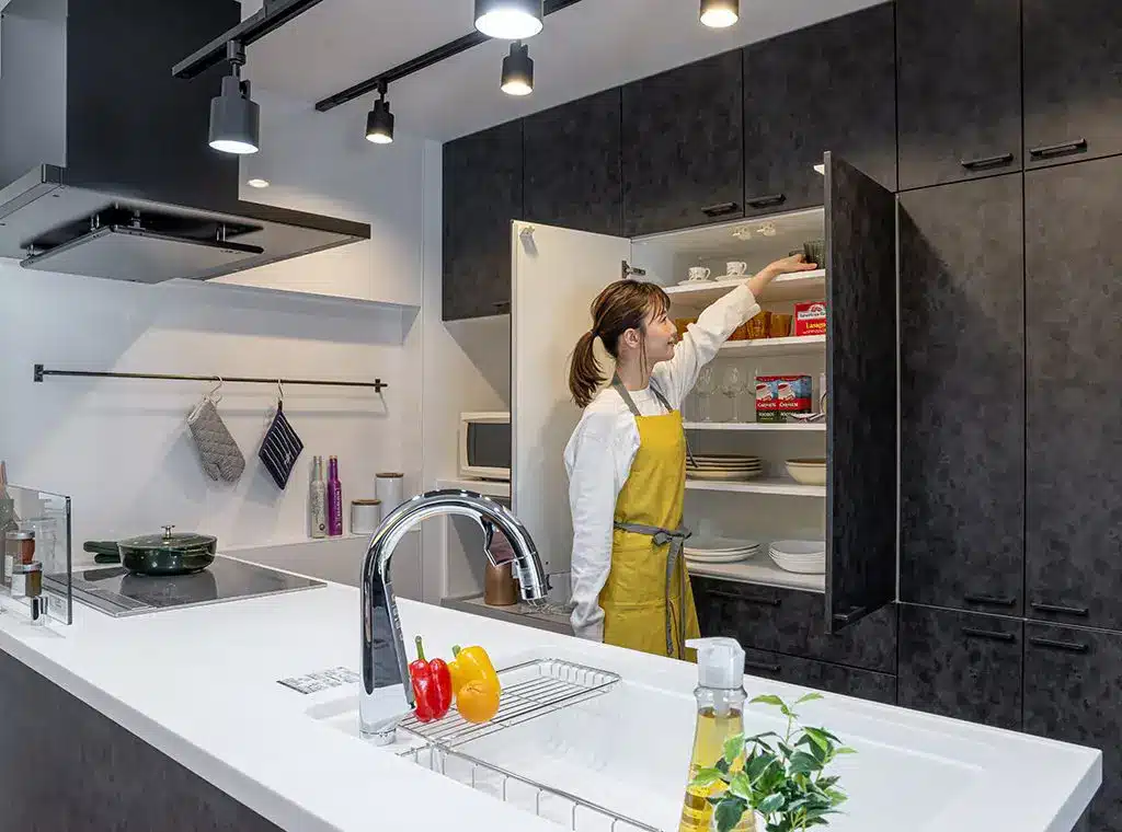 食器棚からグラスを取る女性