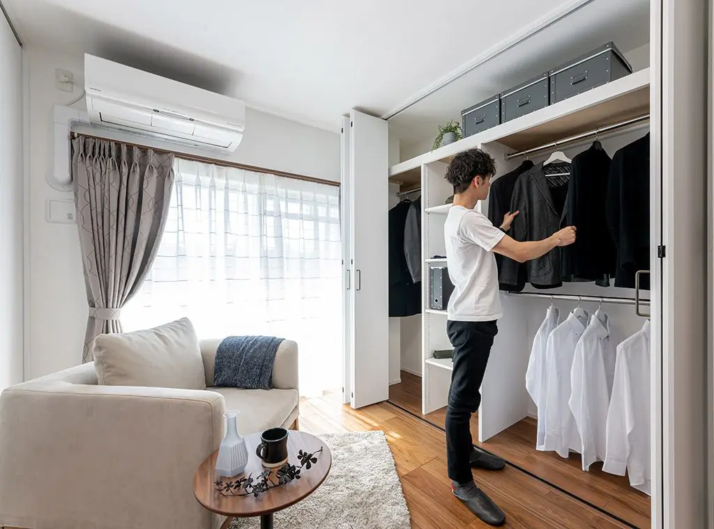 クローゼットからスーツを選ぶ男性