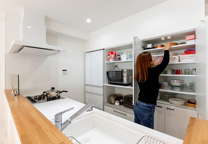 食器棚から物を取り出す女性