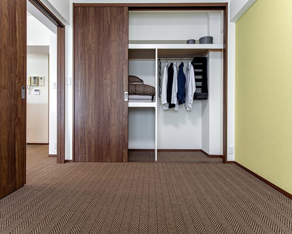 リビング隣の洋室は、建具にウォールナット、アクセントクロスに薄い黄色を使用し落ち着きのある雰囲気に。